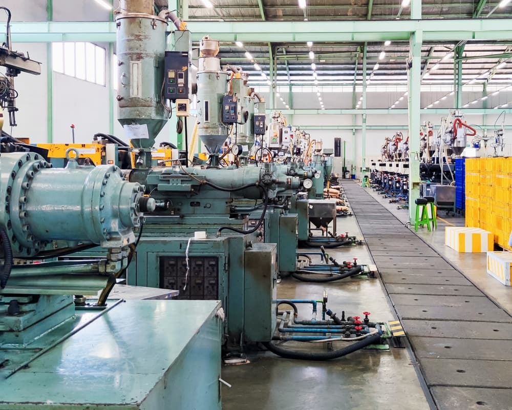 Row of machines on the production floor at a factory, showcasing industrial equipment in a business and manufacturing setting.