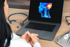 Doctor showing a x-ray of pain in the brain on a laptop. 