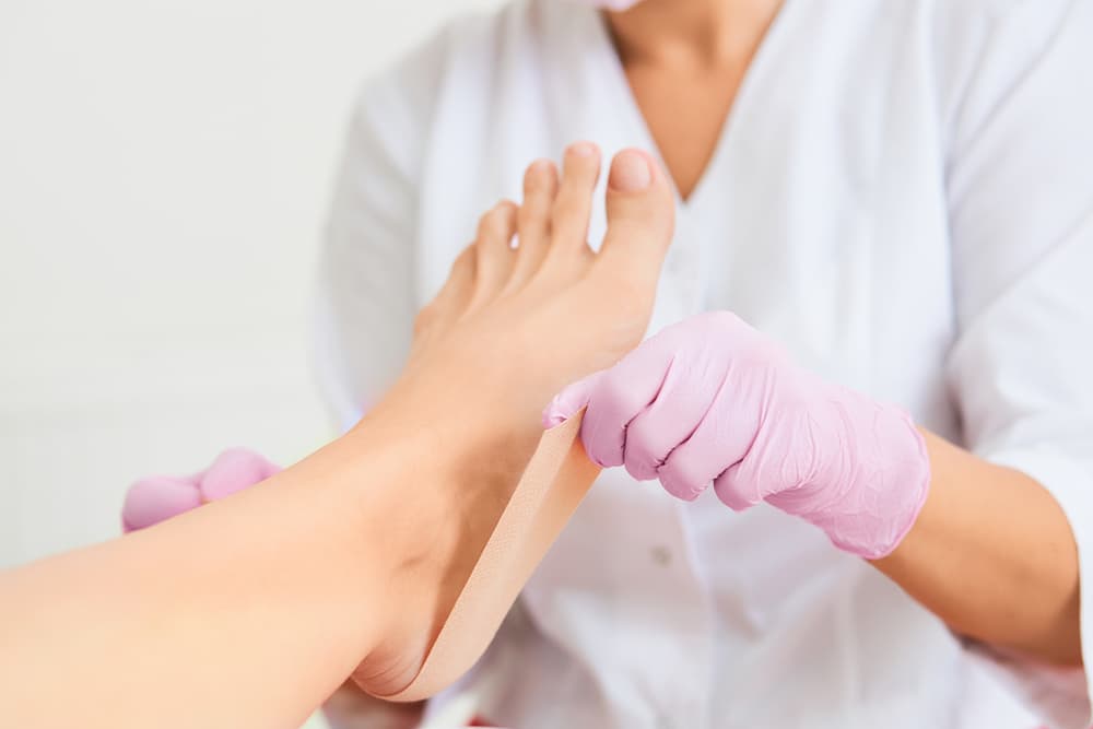 Patient receiving medical pedicure for skin ulceration prevention with podiatrist using polymer gel plates in a podiatry clinic.